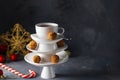 White saucer pyramid with cup of tea on top, like Christmas tree decorated with sweet chocolate truffles, Creative concept,
