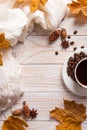White scarf, a cup of coffee with scattered coffee beans, dry yellow leaves on a wooden table. Autumn mood, copy space Royalty Free Stock Photo