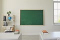 White school classroom interior. Bright lassroom with windows tables chair green board Royalty Free Stock Photo