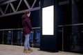 White screen concept - woman looking at blank interactive white display kiosk
