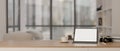 A digital tablet mockup, a camera, a coffee cup, and books on a wooden table in a modern room Royalty Free Stock Photo