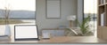 A white-screen digital tablet mockup on a wooden desk in a beautiful minimalist room Royalty Free Stock Photo