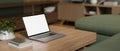 A white-screen laptop computer on a wooden coffee table in a modern and comfortable living room Royalty Free Stock Photo