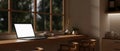 A white-screen laptop mockup on a hardwood desk against the window in a modern, cozy kitchen Royalty Free Stock Photo