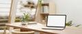 A white-screen laptop mockup on a wooden dining table in a neutral contemporary dining room Royalty Free Stock Photo