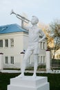 White sculpture of a pioneer with a horn on a pedestal