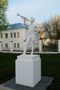 White sculpture of a pioneer with a horn on a pedestal