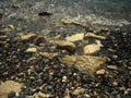 White sea rocks and pebbles washed by wave.