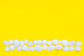 White sea shells laid out as a strip or line on a bright yellow background. Hot summer and beach theme. Copy space Royalty Free Stock Photo