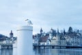 White seagull sitting on a pole, beautiful view of autumn, winter Lucerne historic sites, Hofkirche Church, houses, tourist boats