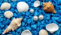 The isolated shells and pearls on the blue background are made of small blue rocks. Royalty Free Stock Photo