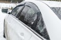 A white sedan car automobile on winter countryside road covered in snow ice close-up, reflection in the window. Snow Royalty Free Stock Photo