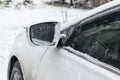 A white sedan car on winter countryside road covered in snow ice close-up, reflection in the window. Snow layer on Royalty Free Stock Photo