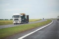 White semi-trailer truck trawl transports oversized machinery on the highway in rainy weather, industry. Copy space for text