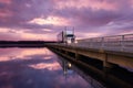 white semi-truck driving on a bridge over calm water at dusk Royalty Free Stock Photo