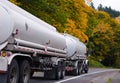 White semi truck with tank trailers on autumn trees road Royalty Free Stock Photo