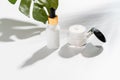 White serum bottle and cream jar, mockup of beauty product brand. Top view on the white background.