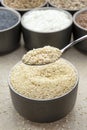 White sesame seeds, sesame seeds in a black saucer on a background of various seeds. Male hand sprinkles sesame seeds