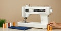 A white sewing machine sits on a table with spools of thread and denim fabric, ready for a sewing project Royalty Free Stock Photo