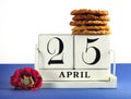 White shabby chic vintage style block calendar for Anzac Day, April 25, with traditional Anzac biscuits