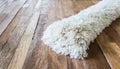 White shaggy carpet on brown wooden floor Royalty Free Stock Photo