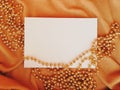 WHITE SHEET OF PAPER ON color FABRIC WITH GOLD HOLIDAY BEADS