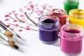 On a white sheet of paper are multi-colored gouache in a jar and brushes for painting. Set for drawing, creativity and hobbies Royalty Free Stock Photo