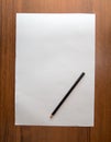 White sheet of paper with a pencil on a wooden background Royalty Free Stock Photo