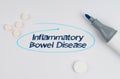 On a white sheet of paper, tablets, a marker and an inscription - Inflammatory Bowel Disease indicated by a drawn oval