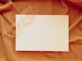WHITE SHEET OF PAPER ON GOLDEN FABRIC WITH GLASSES