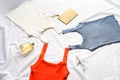 On the white sheet were three tank tops, red, white and blue, interspersed with perfume, model and notebook Royalty Free Stock Photo