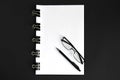 White sheets, pen, glasses and binder clip device for tying paper sheets together on black background close up Royalty Free Stock Photo