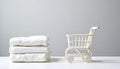 White sheets stacked next to a miniature shopping cart on a table Royalty Free Stock Photo