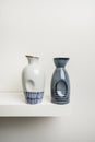 white shelf with some small white and blue porcelain bottles