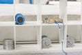 White shelf with sports equipment in a bouldering gym. Workout with weights. Blue massage roller.