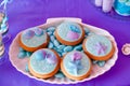 White shell plate full of chocolate candies with blue icing, cookies with shells, stars on the table with shining cloth. Summer Royalty Free Stock Photo