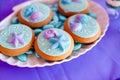 White shell plate full of chocolate candies with blue icing, cookies with shells, stars on the table with shining cloth. Summer Royalty Free Stock Photo