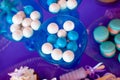 White shell plate full of chocolate candies with blue icing, cookies with shells, stars on the table with shining cloth. Summer Royalty Free Stock Photo