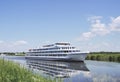 A white ship sails along the river on a clear summer day. Royalty Free Stock Photo