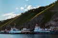 White ships boats in lake baikal near rocks and green mountains with trees in light of sunset Royalty Free Stock Photo