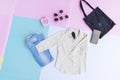 white shirt, blue jeans, brown purse and black bag on multi pastel color background