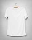 White shirt hanging on cement wall. Empty clothing for design. Back view Royalty Free Stock Photo