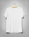 White shirt hanging on cement wall. Empty clothing for design. Front view Royalty Free Stock Photo