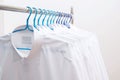 White shirts hanging on rack in a row