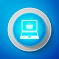 White Shopping basket on screen laptop icon isolated on blue background. Concept e-commerce, e-business, online business Royalty Free Stock Photo