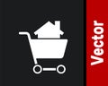 White Shopping cart with house icon isolated on black background. Buy house concept. Home loan concept, rent, buying a Royalty Free Stock Photo