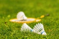 White shuttlecock close-up in a meadow with yellow badminton rackets against a blurred background Royalty Free Stock Photo