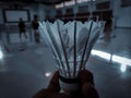 a white shuttlecock in hand on a badminton court background Royalty Free Stock Photo