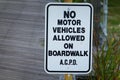 A white sign with black letters prohibiting motor vehicles in the boardwalk Royalty Free Stock Photo