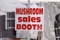 White sign with orange text that says Mushroom Sales Booth